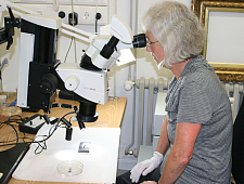 Restauratorin Gütha Klonk am Mikroskop mit Blick auf ein Metallobjekt  (Foto: Hermann Witte)
