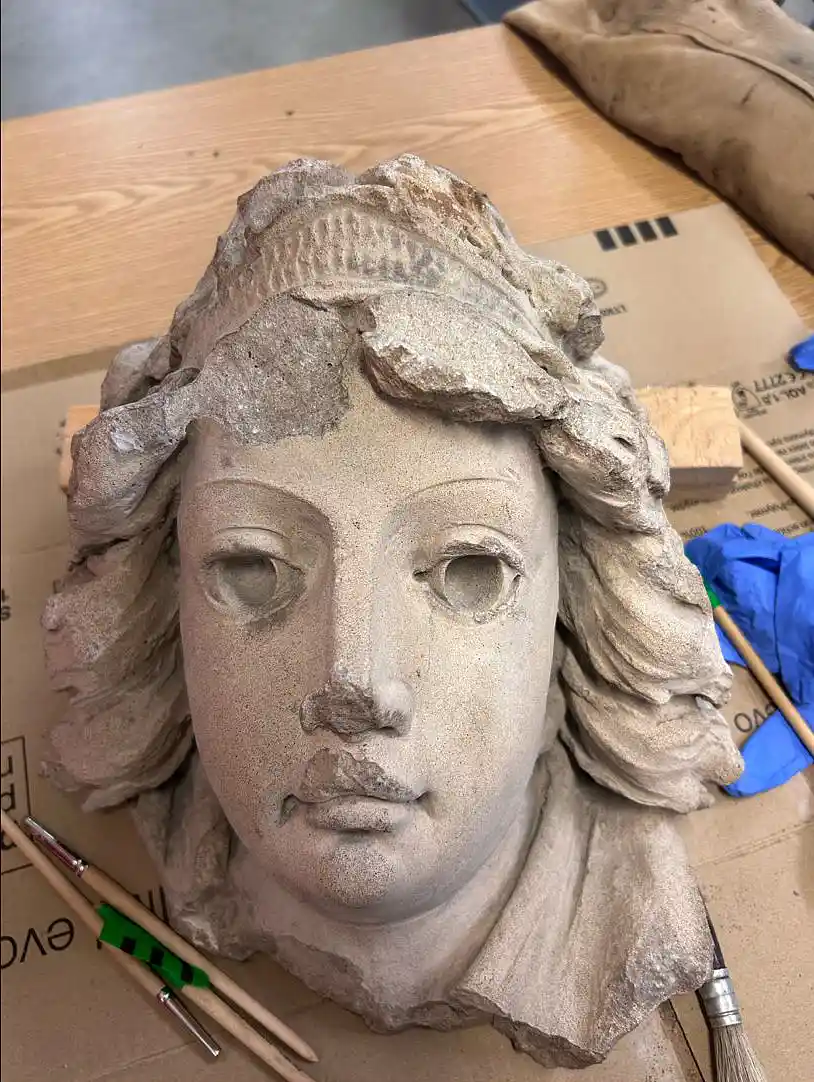 ein Frauenkopf aus Beton im Jugendstil auf dem Tisch, daneben verschiedene Pinsel