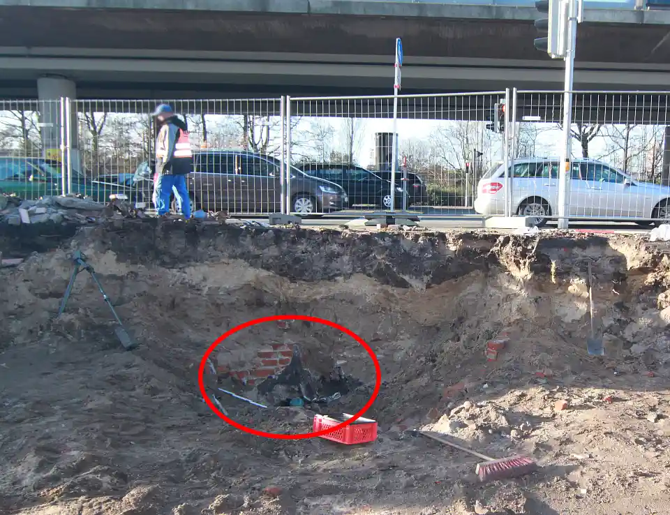 Ausgrabungsfläche, kurz unter dem Straßenpflaster, im Hintergrund befindet sich eine stark begfahrene Straße