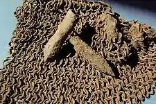 Teil eines Kettenhemds und Armbrustbolzen